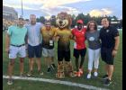 Representatives from the local nonprofit Darkness to Light pose on the field at MUSC Health Stadium with Leo the Lion and Battery legend John Wilson following the Blackbaud Crossbar Challenge at a match in 2017.