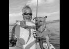 Brody and Captain Greg hold up a trout they caught recently.
